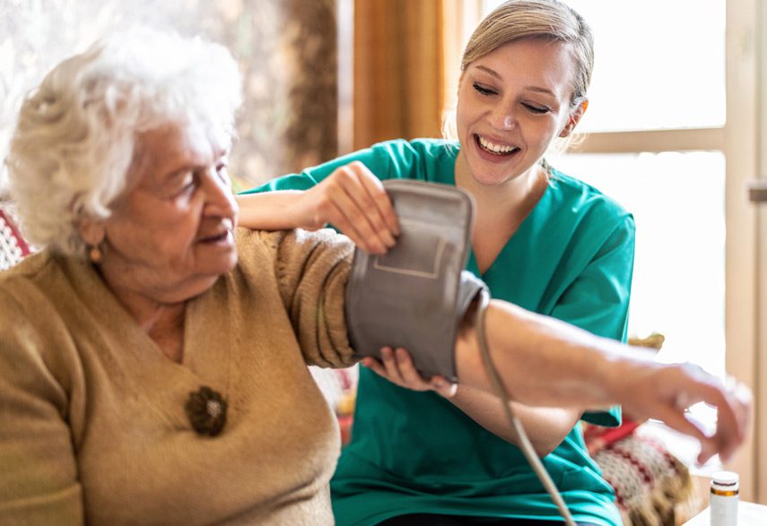 Home-health-aide-checking-hospice-patient’s-blood-pressure