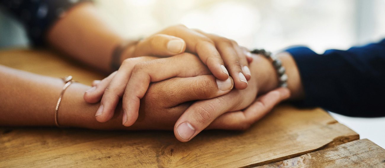 Two-people-holding-hands-to-deal-with-grief