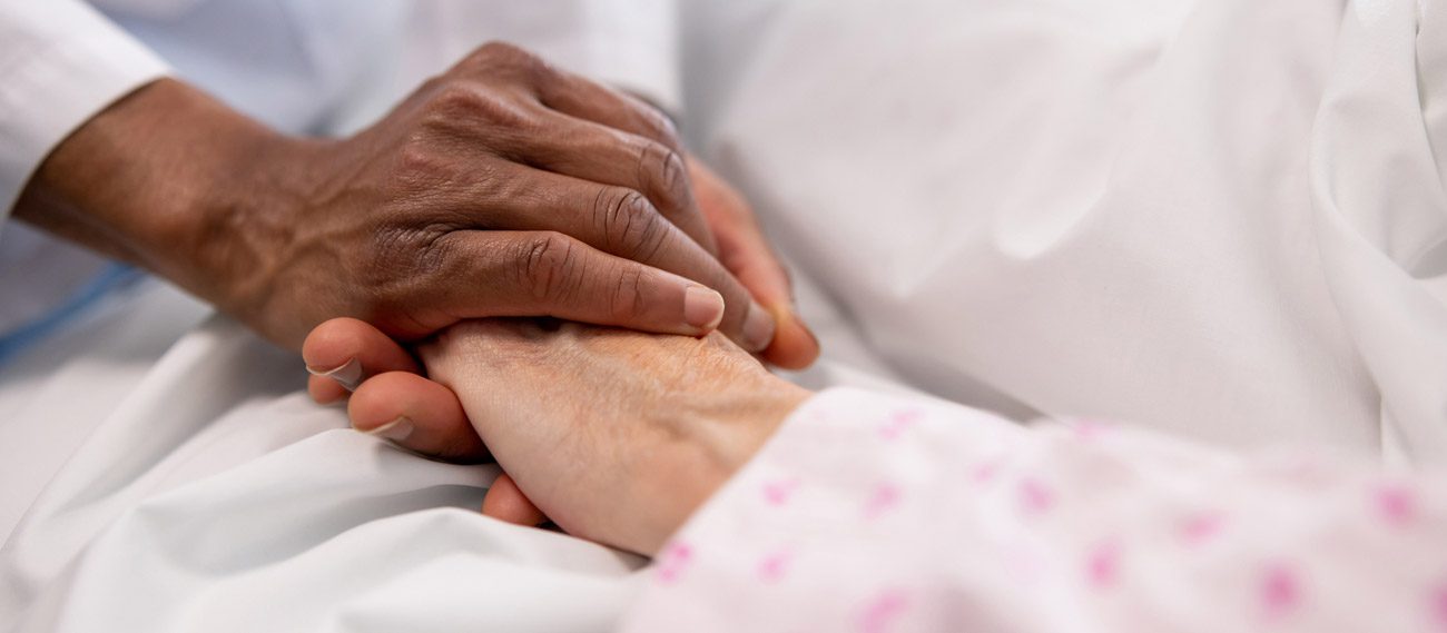 hospice-nurse-holding-patient's-hand-gently