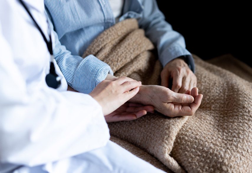 hospice-nurse-sitting-and-holding-hands-with-a-patient